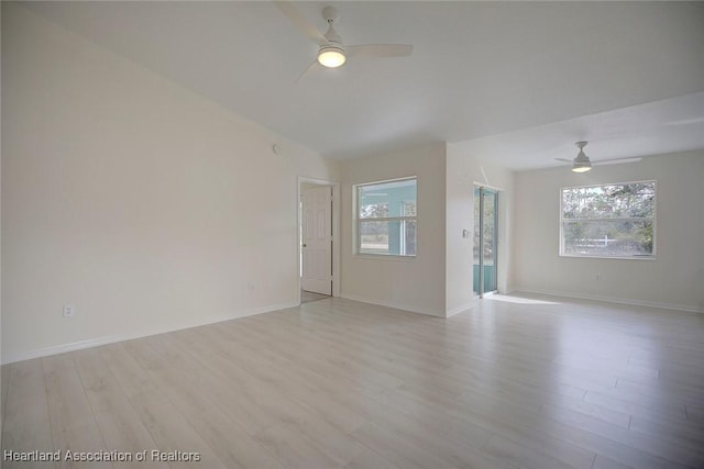 spare room featuring lofted ceiling, ceiling fan, and light wood-type flooring