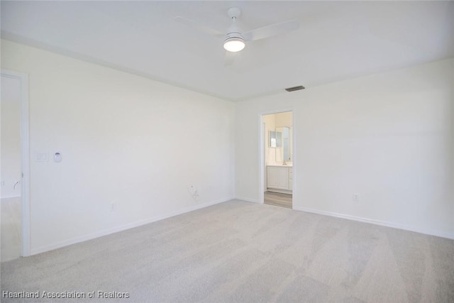 spare room with ceiling fan and light carpet