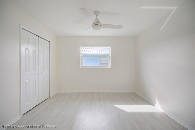 unfurnished bedroom featuring ceiling fan, a closet, and light hardwood / wood-style flooring