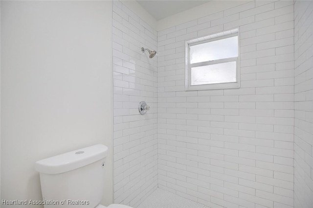 bathroom featuring toilet and tiled shower