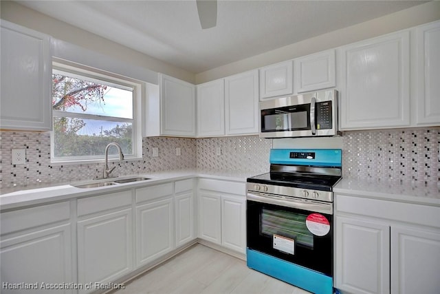 kitchen with white cabinetry, sink, backsplash, and appliances with stainless steel finishes