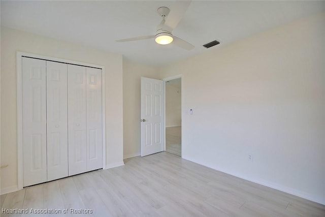 unfurnished bedroom with a closet, ceiling fan, and light hardwood / wood-style flooring