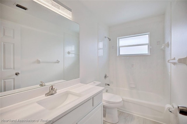 full bathroom featuring tiled shower / bath, vanity, and toilet