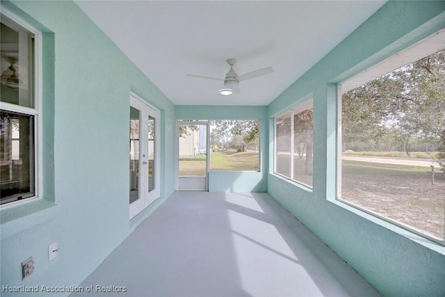 unfurnished sunroom featuring ceiling fan