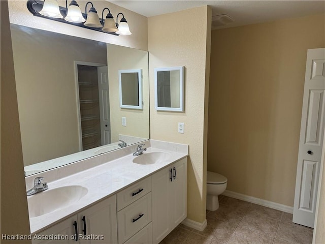 bathroom featuring toilet, vanity, and tile patterned floors