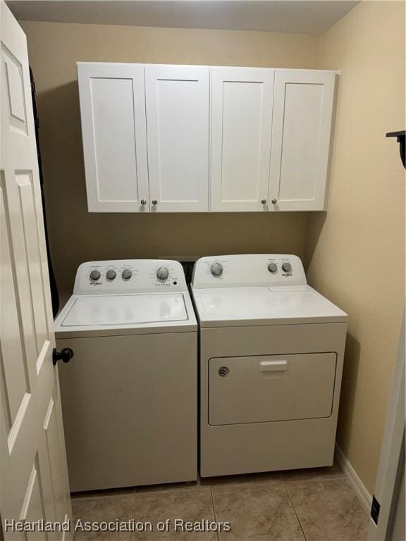 laundry room featuring cabinets, separate washer and dryer, and light tile patterned floors