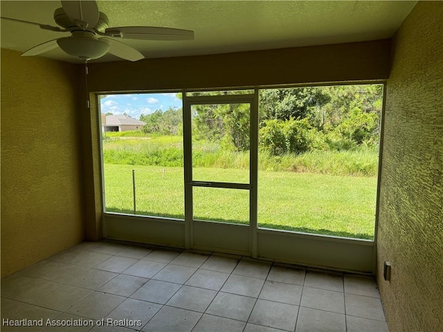 unfurnished sunroom featuring ceiling fan