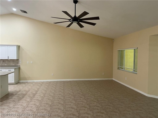 unfurnished living room featuring ceiling fan, light tile patterned floors, and vaulted ceiling