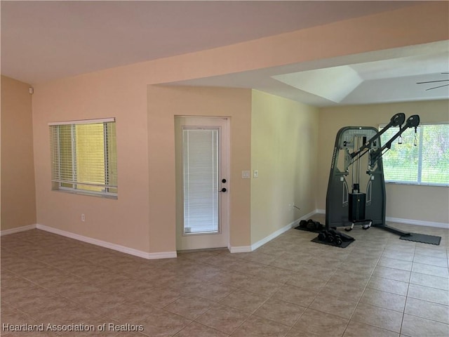 exercise room featuring ceiling fan and light tile patterned floors