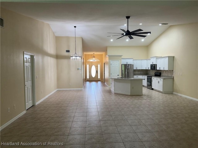 kitchen featuring a center island, ceiling fan, decorative light fixtures, white cabinetry, and stainless steel appliances