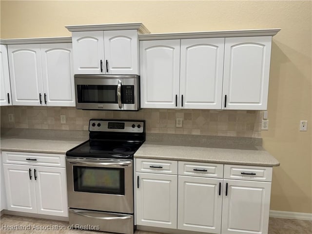 kitchen with white cabinets, appliances with stainless steel finishes, tasteful backsplash, and light tile patterned floors