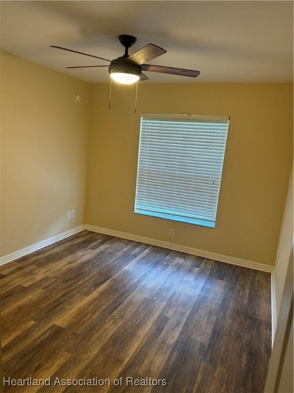 spare room featuring ceiling fan and dark wood-type flooring