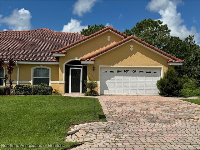 mediterranean / spanish house featuring a garage and a front lawn