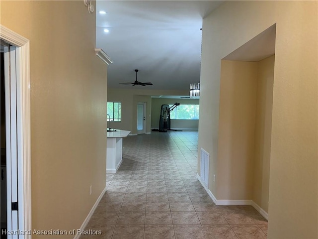 corridor with light tile patterned floors and sink