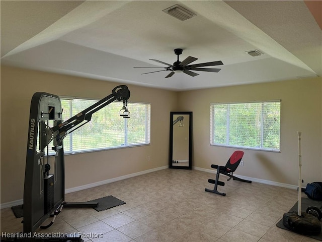 exercise room with ceiling fan, plenty of natural light, and light tile patterned floors