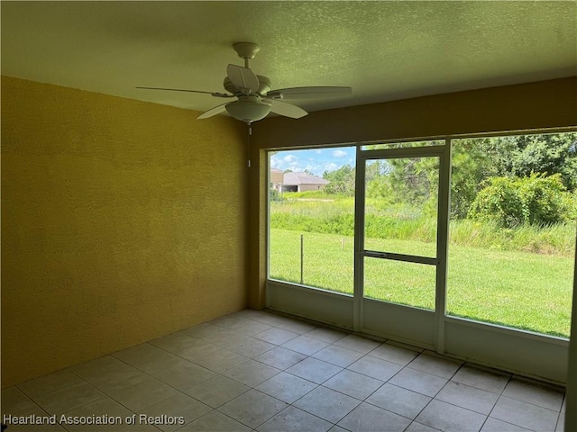 unfurnished sunroom with ceiling fan