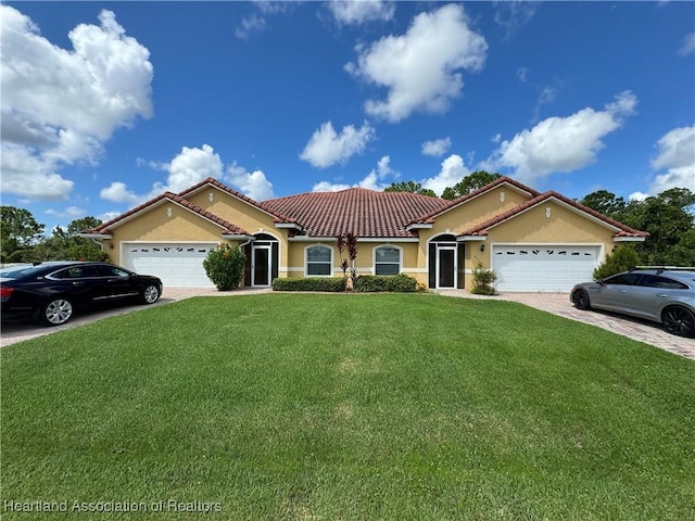 mediterranean / spanish-style home featuring a garage and a front lawn