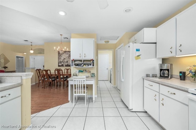 kitchen featuring light tile patterned flooring, white cabinetry, white fridge, and hanging light fixtures