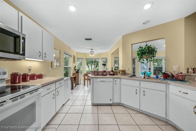 kitchen featuring white cabinets, ceiling fan, white appliances, and light tile patterned floors