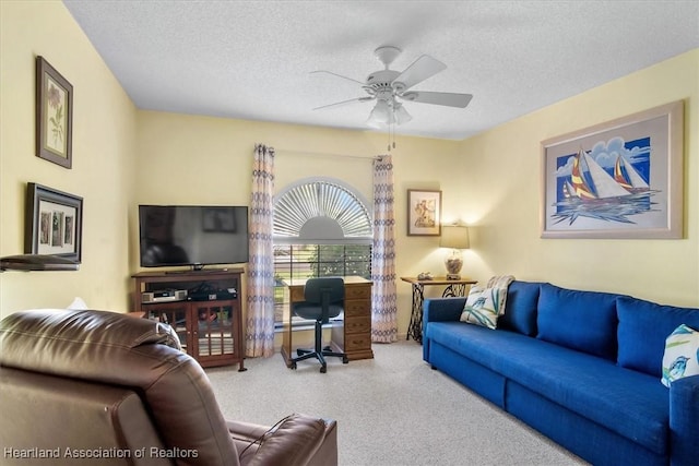 living room with ceiling fan, a textured ceiling, and light carpet