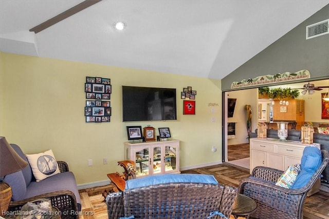 living room featuring hardwood / wood-style flooring, ceiling fan, and vaulted ceiling