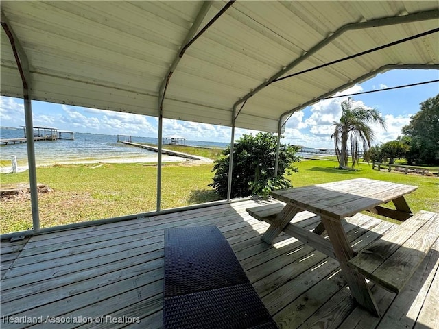 wooden terrace with a yard and a water view