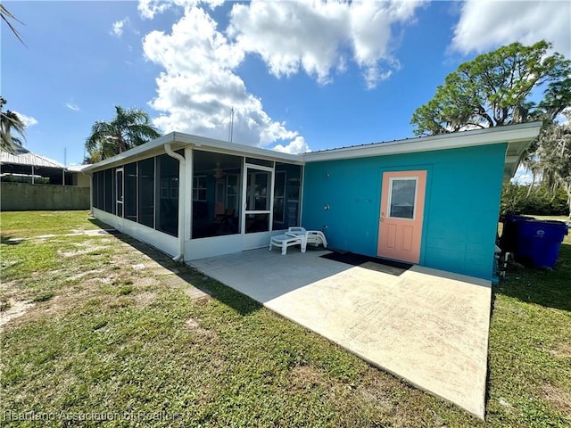 back of property featuring a patio area, a sunroom, and a yard