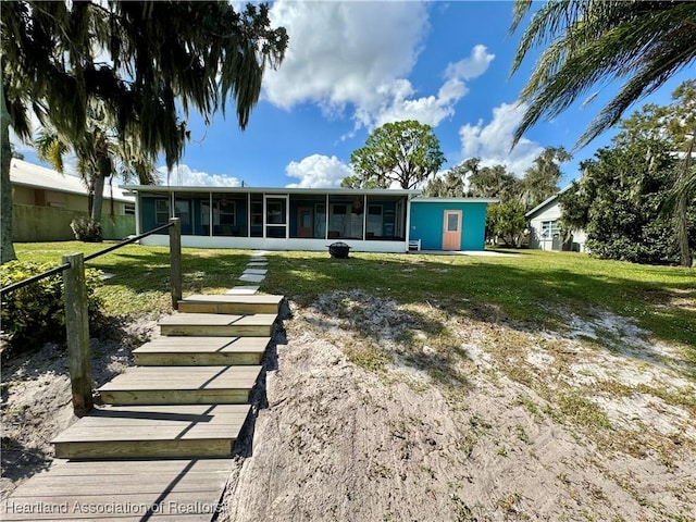 back of house featuring a sunroom and a yard