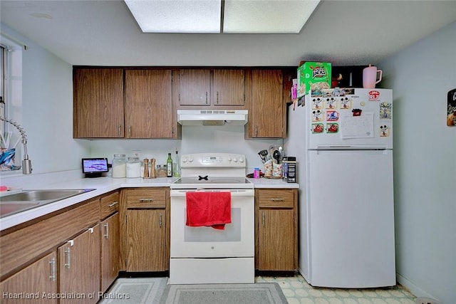 22 W Raymond St, Avon Park, FL 33825 - kitchen with white appliances, under cabinet range hood, light countertops, and brown cabinets