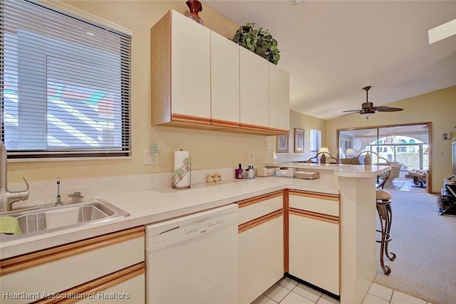 kitchen featuring ceiling fan, dishwasher, sink, kitchen peninsula, and light tile patterned floors