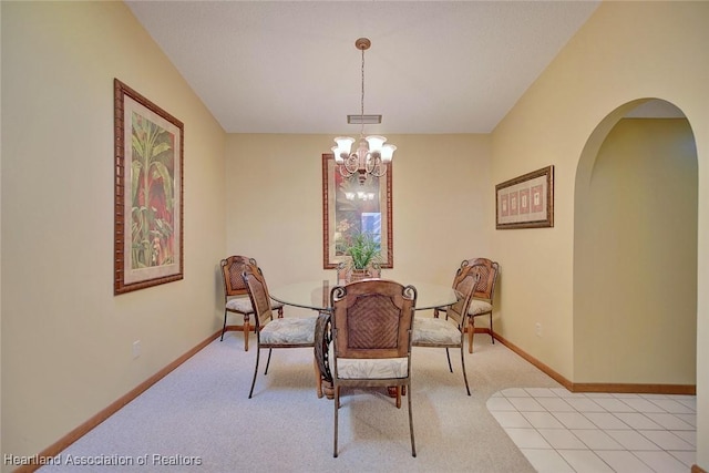 carpeted dining area with a notable chandelier