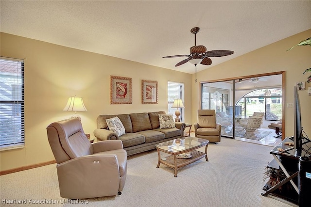 carpeted living room with ceiling fan and lofted ceiling