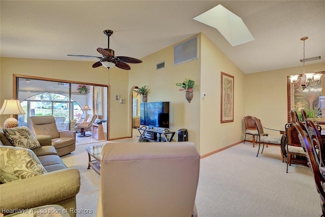 living room with lofted ceiling with skylight, light colored carpet, and ceiling fan with notable chandelier