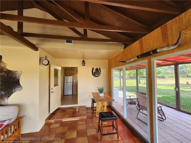 sunroom / solarium with a wealth of natural light, visible vents, and lofted ceiling with beams