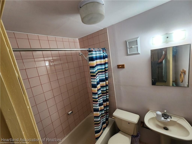 bathroom featuring visible vents, shower / bath combination with curtain, a sink, and toilet