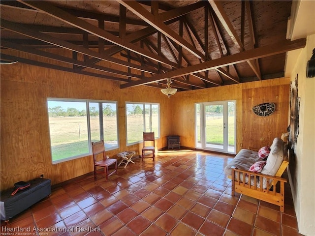 unfurnished sunroom with vaulted ceiling with beams