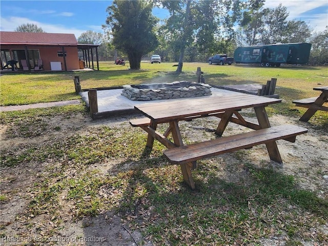 view of home's community with a fire pit and a yard