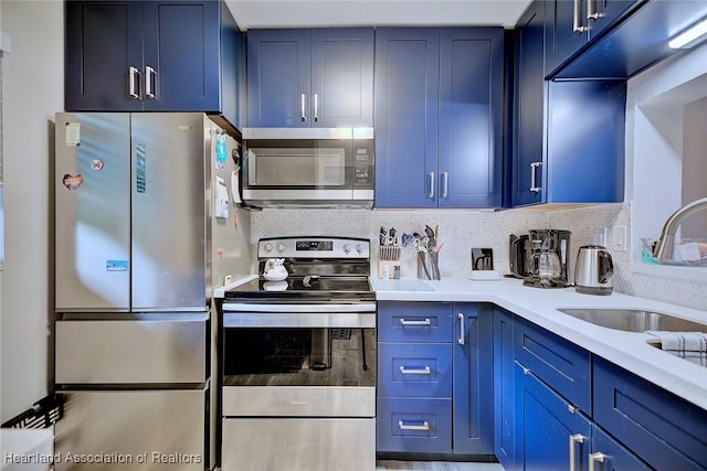 kitchen featuring blue cabinets, appliances with stainless steel finishes, and a sink
