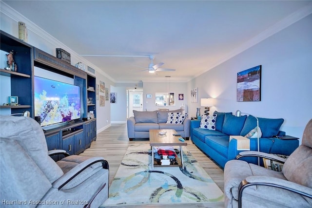 living room featuring ornamental molding, light wood-style floors, baseboards, and a ceiling fan