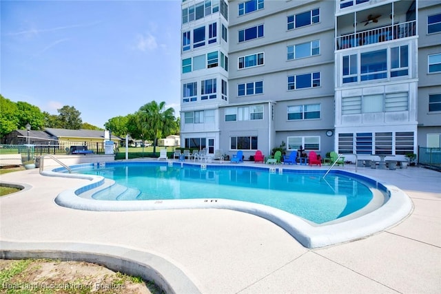 pool featuring fence and a patio