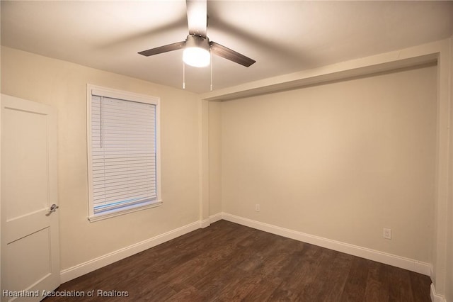 empty room with ceiling fan and dark hardwood / wood-style flooring