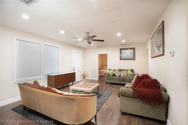 living room featuring ceiling fan and dark hardwood / wood-style flooring