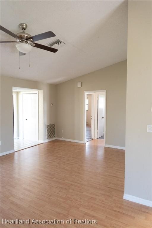 spare room with ceiling fan, lofted ceiling, and light wood-type flooring