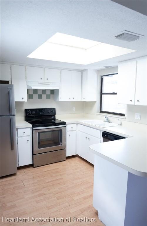 kitchen with kitchen peninsula, white cabinets, stainless steel appliances, and light wood-type flooring