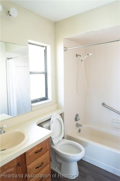 full bathroom with vanity, hardwood / wood-style flooring, toilet, and shower / bathtub combination with curtain