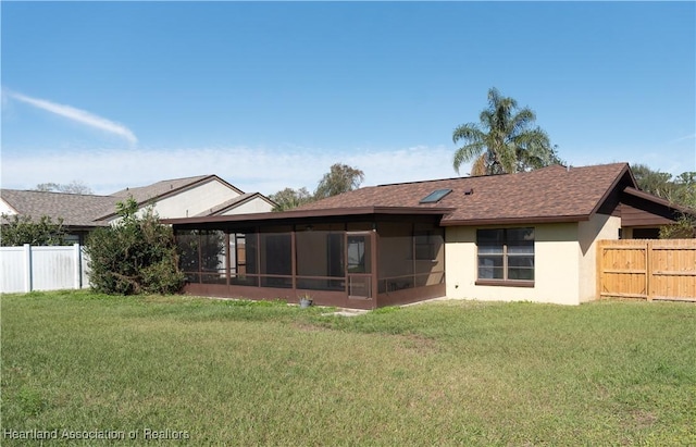 rear view of property with a sunroom and a lawn