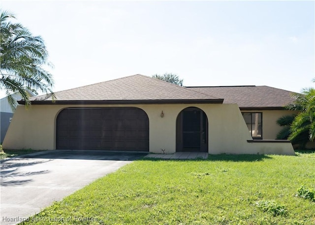 ranch-style house featuring a garage and a front lawn