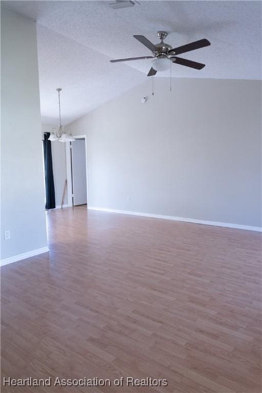 unfurnished room featuring ceiling fan with notable chandelier, wood-type flooring, and lofted ceiling