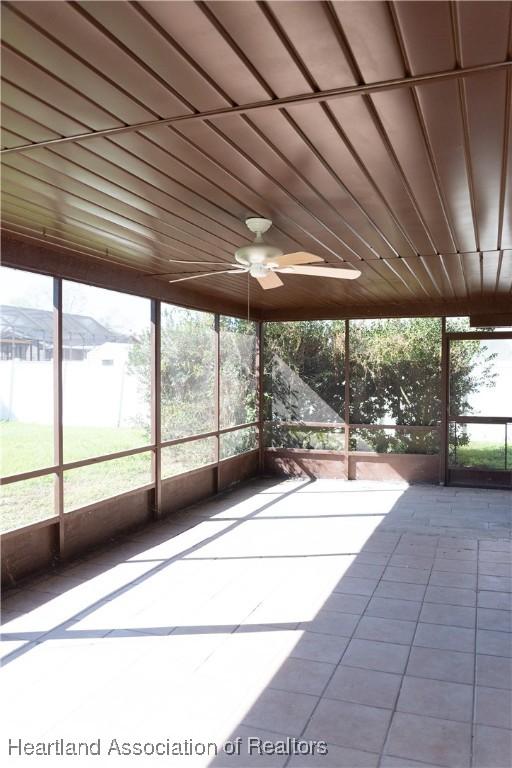 unfurnished sunroom with ceiling fan and wooden ceiling