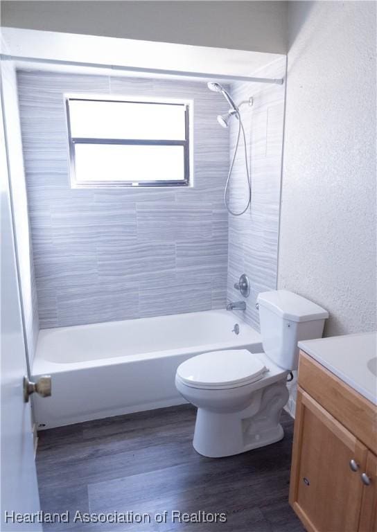 full bathroom with vanity, hardwood / wood-style flooring, toilet, and tiled shower / bath